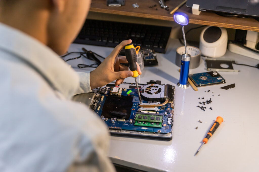 computer repair technician repairing a laptop